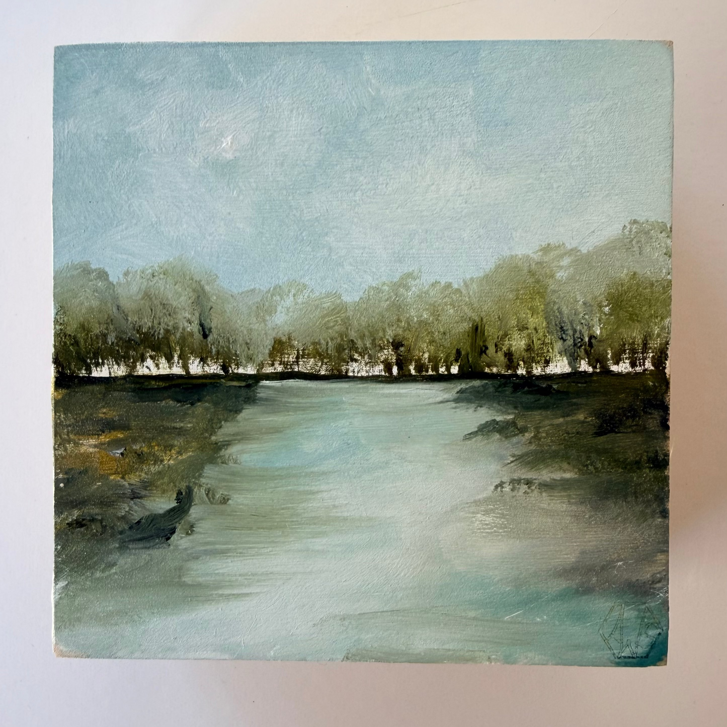 A square painting of a calm river scene with a tree line along the far bank under a pale blue sky, shown against a plain light background.